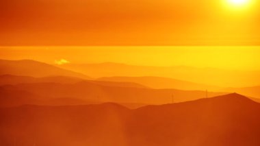 Bulutların üstündeki yüksek dağlarda yanan günbatımı. Portekiz 'de Serra da Estrela.