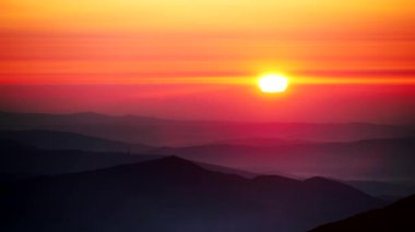 Bulutların üstündeki yüksek dağlarda yanan günbatımı. Serra da Estrela Portekiz 'de. Güneşin batışının zamanı.