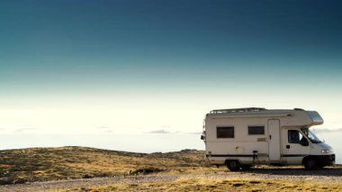 Karavan bulutların üstündeki dağlarda kamp yapıyor. Portekiz 'deki Serra da Estrela' nın Torre Dağı zirvesi. Ziyaret yeri. Gezici evde macera ve tatil.