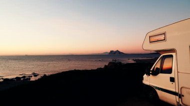 Sabah kumsalda karavan kampı, Punta Mala, Endülüs İspanya. Ufukta Cebelitarık kayası, İspanya kıyılarında İngiliz denizaşırı toprakları.