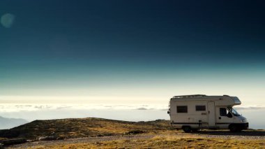 Karavan bulutların üstündeki dağlarda kamp yapıyor. Portekiz 'deki Serra da Estrela' nın Torre Dağı zirvesi. Ziyaret yeri. Gezici evde macera ve tatil.