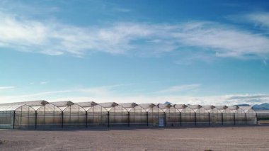 İspanya kıyılarında büyük ticari cam seralar ile hareket eden bulutların zaman akışı. Endüstriyel tarım. Murcia bölgesi, İspanya.