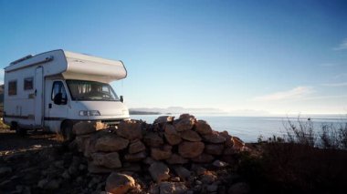 Kamp aracı deniz kenarında kamp yapıyor. Karavanla tur. Karavan tatili. Doğa ve faaliyetler.