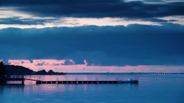 Akşam gün batımında su ve rıhtımda hareket eden bulutların hızlanması. Baltık Denizi, Puck Bay in poland ve hel yarımadası ufukta. Deniz kıyısı manzarası.
