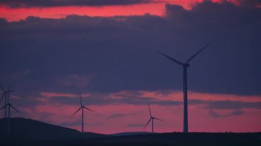 Gün batımında tepelerde rüzgar türbinleri. Ardales, Malaga ili, Endülüs İspanya yakınlarındaki yenilenebilir enerji üretimi için enerji jeneratörü çiftliği.