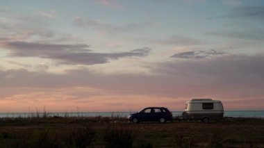Deniz kıyısında kamp yapan karavan karavanıyla birlikte kıyı arazisinde bulutların hızlanması. Capicorb, Valencia bölgesi İspanya. Gezici evle tatil.