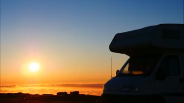 Karavan bulutların üzerinde gün doğumunda dağlarda kamp kuruyor. Portekiz, Serra da Estrela 'nın Torre Dağı zirvesi. Karavanla seyahat ediyorum. Ziyaret yeri. Zaman Uygulaması