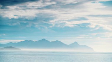 Zaman bulutları ufukta kayalarla kıyı boyunca hareket ediyor. Deniz manzarası. Mazarron Körfezi Akdeniz Bölgesi, Murcia İspanya