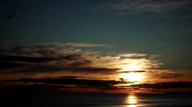Sabahın erken saatlerinde denizde hareket eden bulutların hızlanması, güneşin doğması. Doğa manzarası. Gandia Sahili, Valencia İspanya.