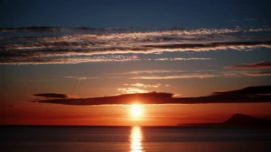 Sabahın erken saatlerinde denizde hareket eden bulutların hızlanması, güneşin doğması. Doğa manzarası. Gandia Sahili, Valencia İspanya.