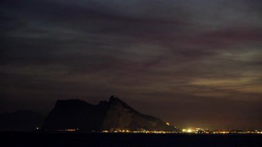 Bulutlar Cebelitarık Kayası 'nın üzerinde gece vakti hareket ediyor. Torrecarbonera Sahili, Punta Mala, Endülüs İspanya. Turist eğlencesi.