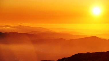 Bulutların üstündeki yüksek dağlarda yanan günbatımı. Portekiz 'de Serra da Estrela.