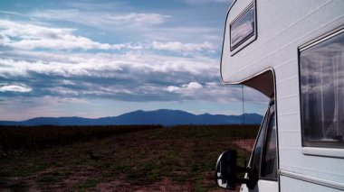 Kamp aracı, İspanya 'da doğada kamp yapan eğlence aracı. Karavanla seyahat ediyorum. Karavan tatili. Bulutlar gökyüzünde hareket ediyor. Zaman aşımı