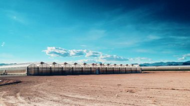 İspanya kıyılarında büyük ticari cam seralar ile hareket eden bulutların zaman akışı. Endüstriyel tarım. Murcia bölgesi, İspanya.