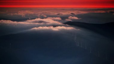 Rüzgar türbinleri gün batımında bulutların üzerinde. Portekiz 'deki Torre Dağı tepesinden Serra da Estrela' nın görüntüsü.