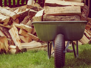 Dışarıda odun yığını ve el arabası var. Kış için hazırlık.