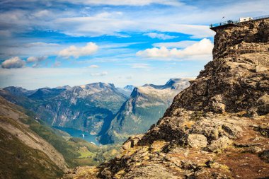 Dalsnbba bölgesinden Geirangerfjord ile panoramik dağlar manzarası. Geiranger Skywalk dağdaki platformu uzaktan görüyor. Norveç.