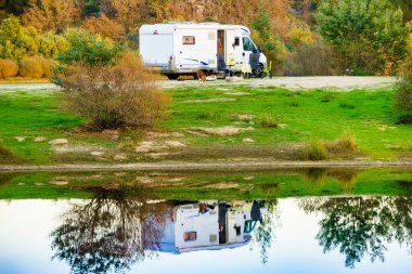 Doğada kamp yapmak. Göl kıyısındaki kamp aracı suya yansıyor. Povoa e Meadas Barajı, Castelo de Vide, Alentejo Portekiz. Karavanla git..