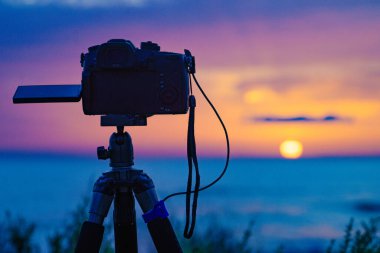 Tripodun üstündeki profesyonel kamera deniz üzerinde güneşin doğuşunu gösteren bir video çekiyor. Fotoğraf:.