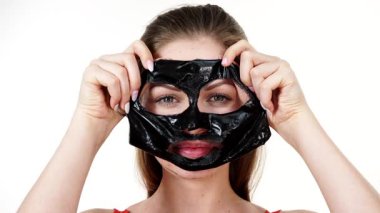 Karbonhidratlı siyah maskesini yüzünden, beyazın üstüne çıkaran genç bir kadın. Genç kız yağlı cildiyle ilgileniyor, gözenekleri temizliyor. Güzellik tedavisi. Cilt bakımı.