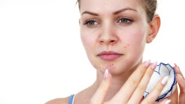 Maske takan genç bir kadın yüzüne nemlendirici krem sürüyor. Cilt nemlendiricisine dikkat eden bir kız. Cilt bakımı.