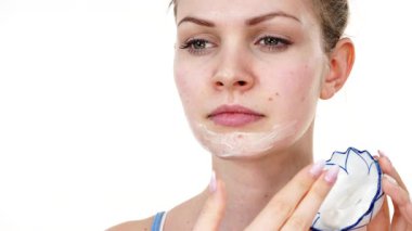 Maske takan genç bir kadın yüzüne nemlendirici krem sürüyor. Cilt nemlendiricisine dikkat eden bir kız. Cilt bakımı.