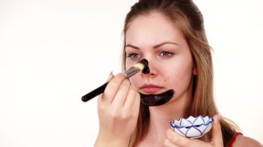 Genç bir kadın yüzüne karbonhidrat temizleme maskesi takıyor, yüzüne, beyaza. Genç kız yağlı cildiyle ilgileniyor, gözenekleri temizliyor. Güzellik tedavisi. Cilt bakımı.