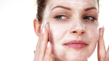 Maske takan genç bir kadın yüzüne nemlendirici krem sürüyor. Cilt nemlendiricisine dikkat eden bir kız. Cilt bakımı.