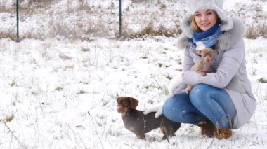 Genç kadın köpekleriyle oynuyor, pinscher ratter prazsky krysarik ve dachshund, kış havasında açık havada..