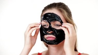Karbonhidratlı siyah maskesini yüzünden, beyazın üstüne çıkaran genç bir kadın. Genç kız yağlı cildiyle ilgileniyor, gözenekleri temizliyor. Güzellik tedavisi. Cilt bakımı.