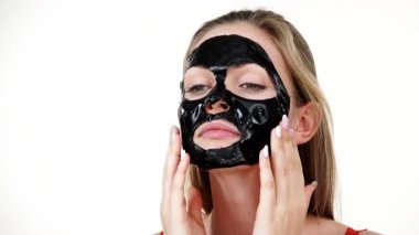 Karbonhidratlı siyah maskesini yüzünden, beyazın üstüne çıkaran genç bir kadın. Genç kız yağlı cildiyle ilgileniyor, gözenekleri temizliyor. Güzellik tedavisi. Cilt bakımı.