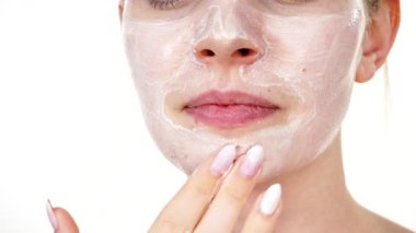 Maske takan genç bir kadın yüzüne nemlendirici krem sürüyor. Cilt nemlendiricisine dikkat eden bir kız. Cilt bakımı.