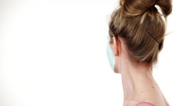 Yüzünde beyaz yeşil çamur maskesi olan genç bir kadın. Genç kız yağlı cildiyle ilgileniyor, gözenekleri temizliyor. Güzellik tedavisi. Cilt bakımı.