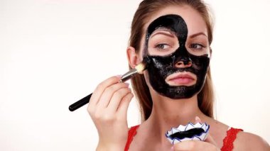 Genç bir kadın yüzüne karbonhidrat temizleme maskesi takıyor, yüzüne, beyaza. Genç kız yağlı cildiyle ilgileniyor, gözenekleri temizliyor. Güzellik tedavisi. Cilt bakımı.