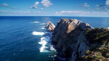 Zaman ayarlı. Faro de Cabo Penas 'tan Bisscay Körfezi' ne. Atlantik Okyanusu 'nun deniz manzarası ve kayalık kıyı şeridi. Kuzey İspanya 'da yüksek uçurumları olan deniz kıyısı.