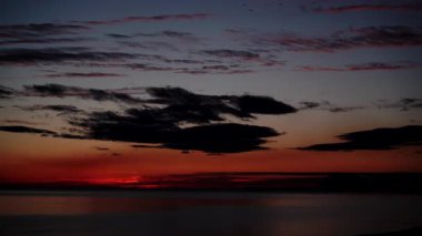 Sabahın erken saatlerinde denizde hareket eden bulutların hızlanması, güneşin doğması. Doğa manzarası. Gandia Sahili, Valencia İspanya.