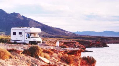 Kayalıklarda kamp yapan kampçılarla deniz manzarası. Akdeniz bölgesi Mazarron, Sierra de las Moreras Murcia İspanya. Motorlu ev tatili.