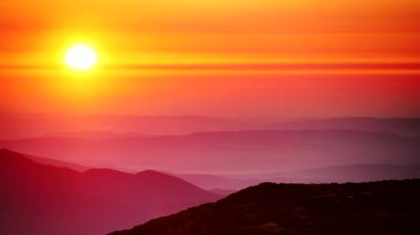 Bulutların üstündeki yüksek dağlarda yanan günbatımı. Portekiz 'de Serra da Estrela.