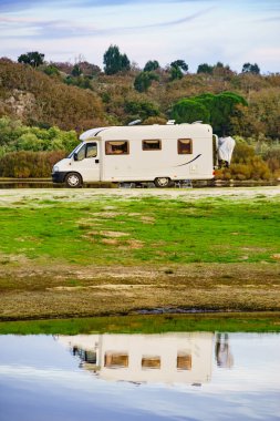 Doğada kamp yapmak. Göl kıyısındaki kamp aracı suya yansıyor. Povoa e Meadas Barajı, Castelo de Vide, Alentejo Portekiz. Karavanla git..