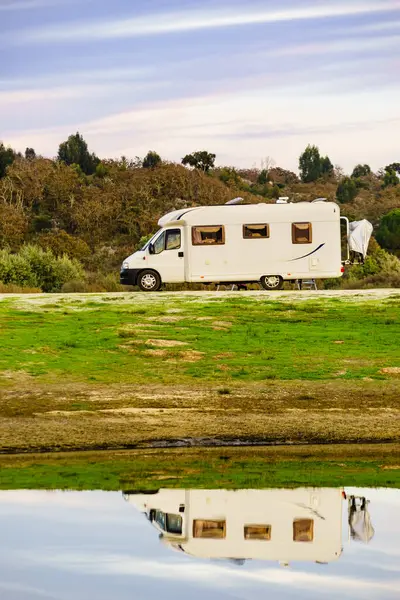 Doğada kamp yapmak. Göl kıyısındaki kamp aracı suya yansıyor. Povoa e Meadas Barajı, Castelo de Vide, Alentejo Portekiz. Karavanla git..