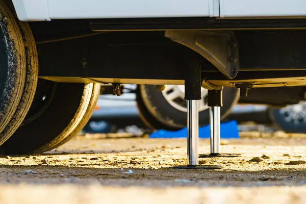 Kamp için otomatik seviye sistemi. Hidrolik sabit bacak kullanımda. Arkadaki karavan için mavi rampa tıkanıklığı.