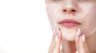 Maske takan genç bir kadın yüzüne nemlendirici krem sürüyor. Cilt nemlendiricisine dikkat eden bir kız. Cilt bakımı.