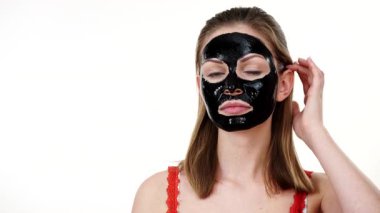 Yüzünde, beyaz karbonhidrat temizleme maskesi olan genç bir kadın. Genç kız yağlı cildiyle ilgileniyor, gözenekleri temizliyor. Güzellik tedavisi. Cilt bakımı.