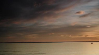 Sabahın erken saatlerinde denizde hareket eden bulutların hızlanması, güneşin doğması. Doğa manzarası. Gandia Sahili, Valencia İspanya.