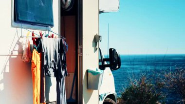 Sahilde kamp yapmak. Giysileri kurumaya bırakılmış bir karavan. Karavanla tatiller.