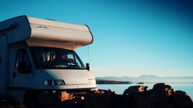 Kamp aracı deniz kenarında kamp yapıyor. Karavanla seyahat ediyorum. Karavan tatili. Doğa ve faaliyetler.