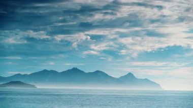 Zaman bulutları ufukta kayalarla kıyı boyunca hareket ediyor. Deniz manzarası. Mazarron Körfezi Akdeniz Bölgesi, Murcia İspanya