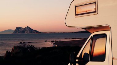 Sabah kumsalda karavan kampı, Punta Mala, Endülüs İspanya. Ufukta Cebelitarık kayası, İspanya kıyılarında İngiliz denizaşırı toprakları.