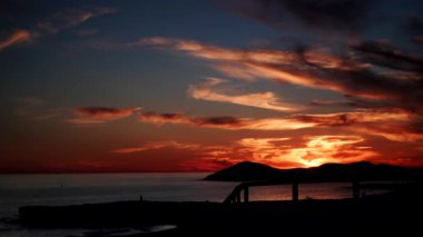 Deniz Burnu. Deniz kıyısında kırmızı turuncu renkli günbatımı. Doğa, kıyı manzarası. Zaman aşımı