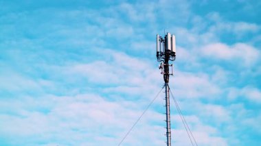 Telekomünikasyon kulesinin üzerinde 4G veya 5G hücresel ağ anteniyle hareket eden beyaz bulutların zaman akışı. Yeni mobil yayın teknolojisi üretimi.